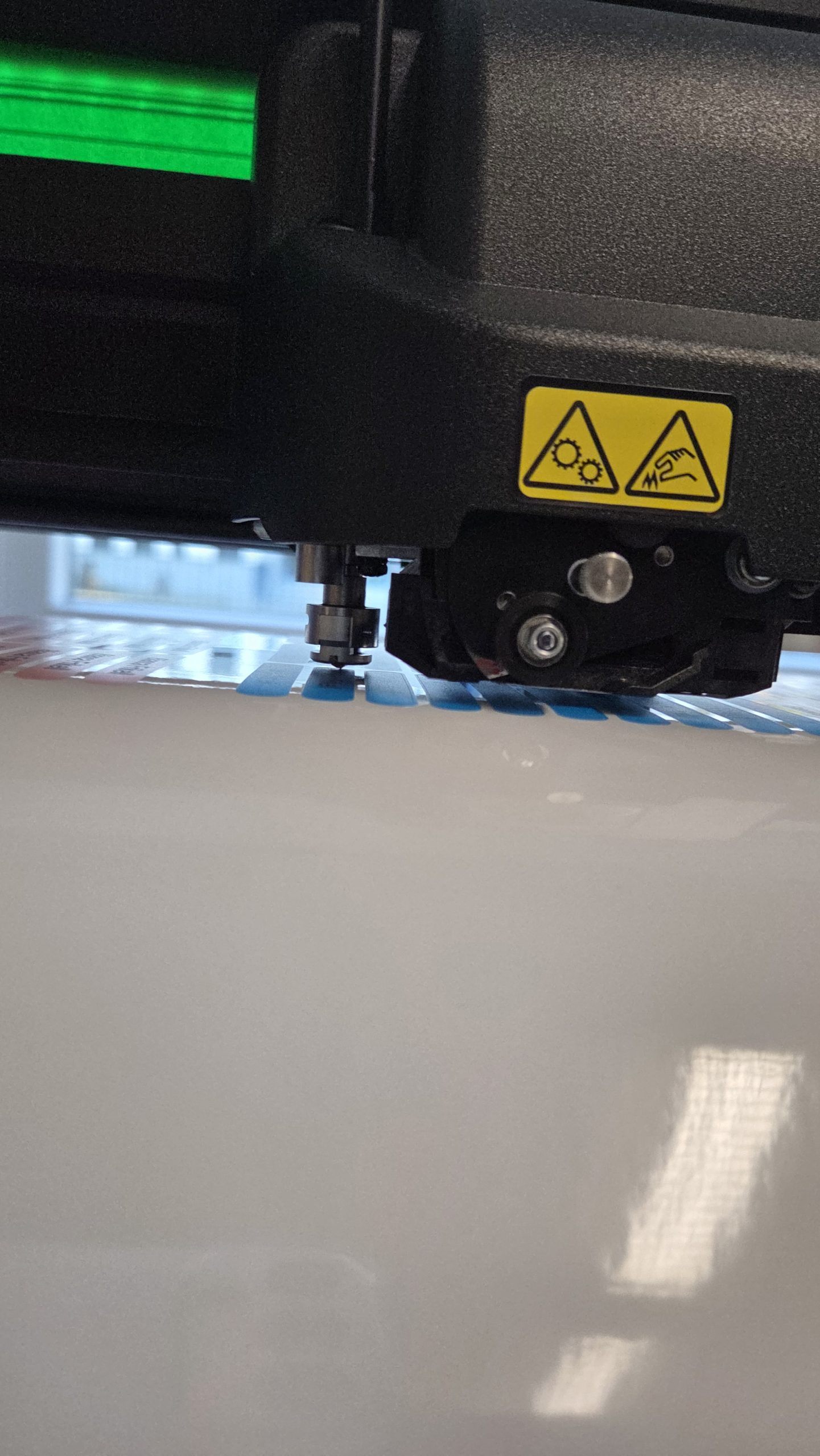 Detailaufnahme während der Produktion: Effizienter Konturschnitt der kleinformatigen Namensaufkleber und Namensetiketten mit dem Rollenschneideplotter S3 T 140 von Summa