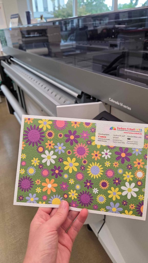 DESARDI® Eco Stucco Sand 180 g bedruckt auf der Canon Colorado M-Serie mit einem bunten Blumenmuster auf hellgrünem Hintergrund. Der Zuschnitt der Muster erfolgte auf dem Flachbettschneideplotter Summa F-Serie. Das Muster erstellte Farben-Frikell | WTB.